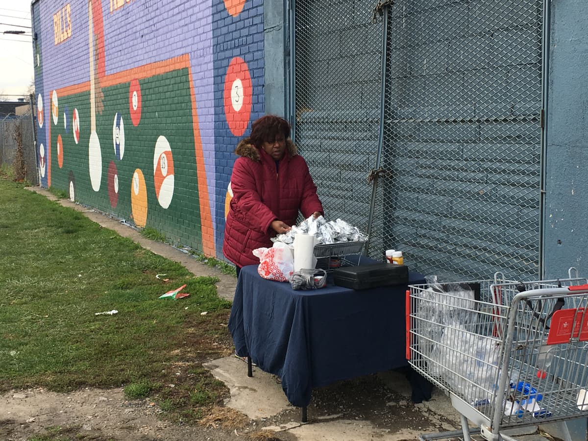Karen preparing the distribution table by the Bills Recreation mural