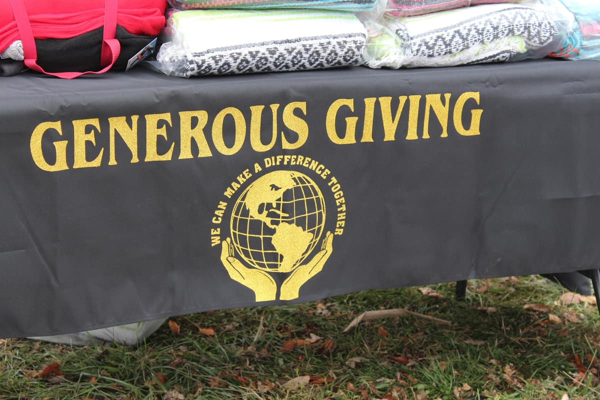 Generous Giving branded table with logo at distribution event